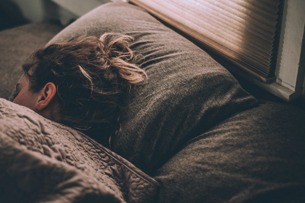 Girl sleeping on brown sheets.